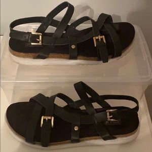 Black strap sandals. Gold buckles and accents.